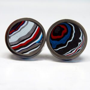 Colorful layered stone earrings on white background.