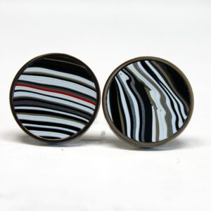 Striped-pattern round cufflinks on white background.