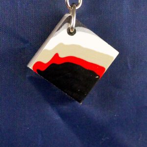 Square pendant with layered colors on chain.