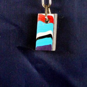 Colorful pendant with abstract design on chain.