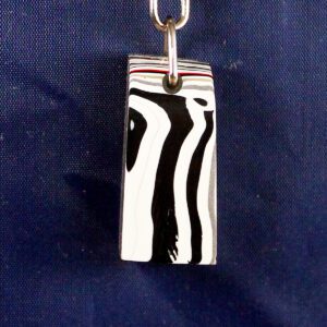 Black and white striped pendant on chain.