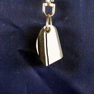 Shiny metal pendant on blue fabric background.