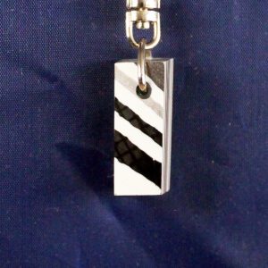 Rectangular metal keychain with black stripes.