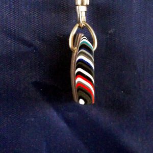 Striped pendant on blue fabric background.