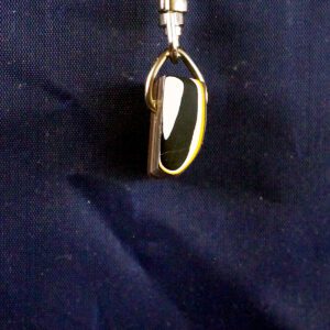 Black and gold teardrop pendant on fabric.
