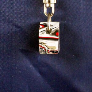 Colorful abstract patterned ring on chain.