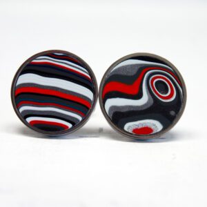 Round earrings with red, black, white patterns.