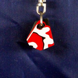 Red and white patterned keychain on blue.