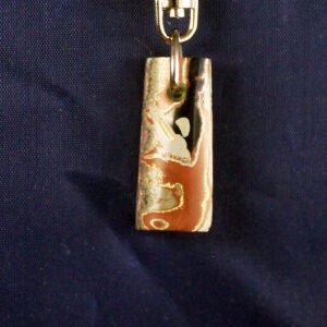 Stone pendant with abstract pattern on blue.