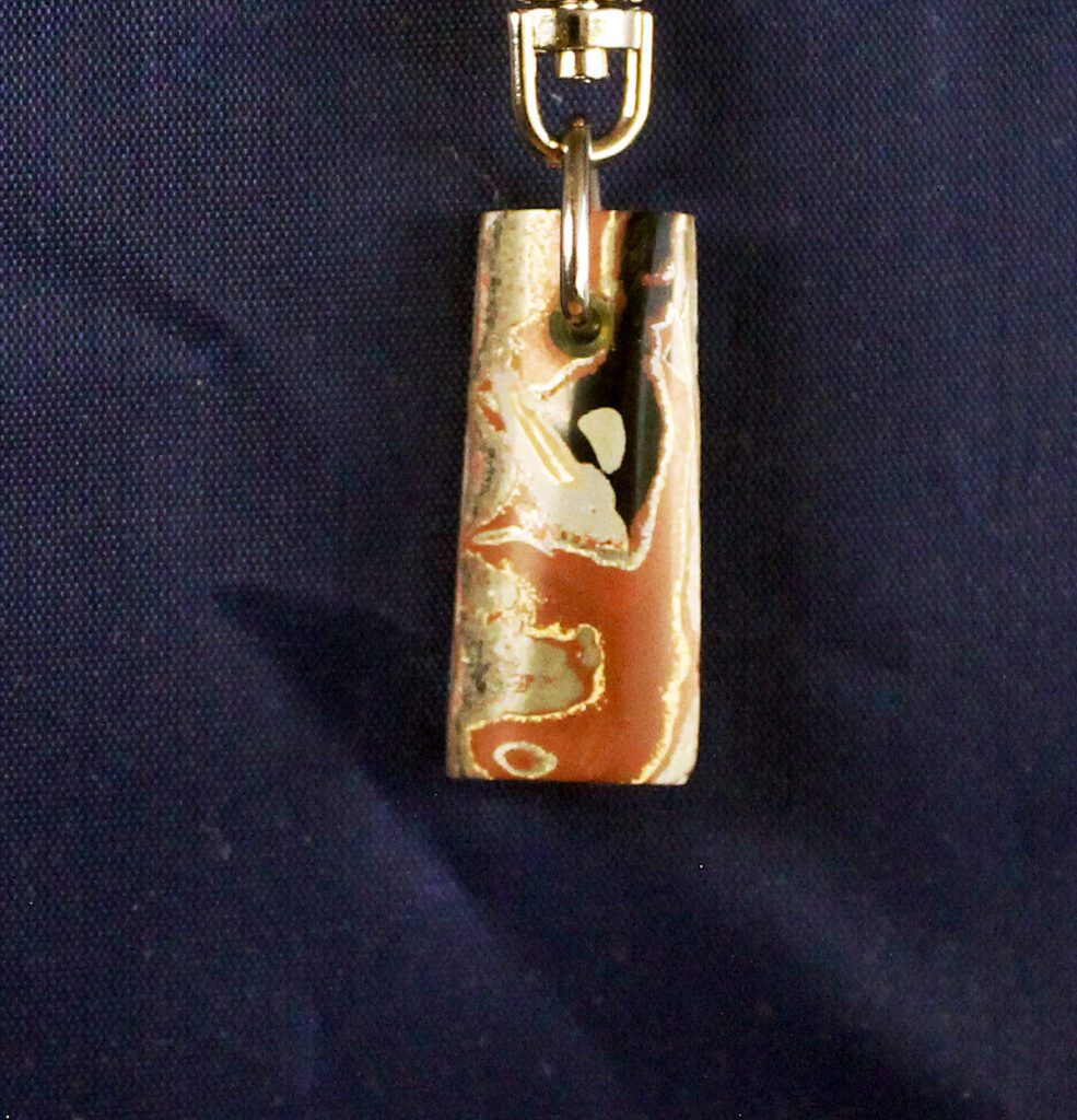 Stone pendant with abstract pattern on blue.