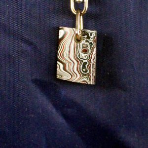 Colorful pendant with swirling patterns on fabric.