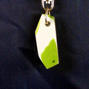 Green and white keychain on dark background.