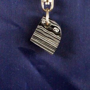 Black and white striped keychain against fabric.