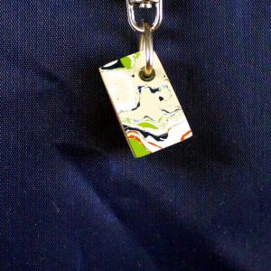 Colorful abstract keychain on blue fabric.