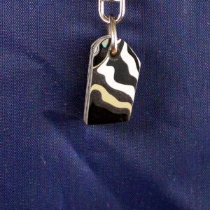 Black and white patterned pendant on chain.