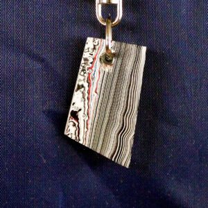 Striped keychain with abstract pattern design.
