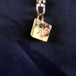 Colorful cube keychain on dark fabric.