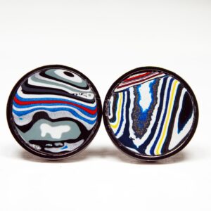 Colorful marbled design earrings on white background.