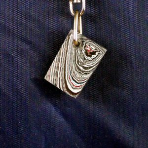 Layered rectangular pendant on dark background.