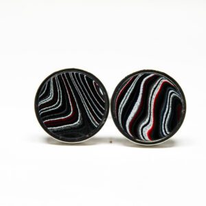 Two circular earrings with abstract patterns.