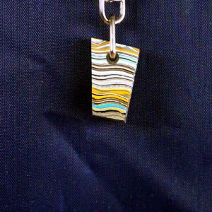 Colorful striped pendant on dark background.