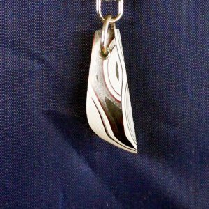 Metal pendant with abstract pattern design.