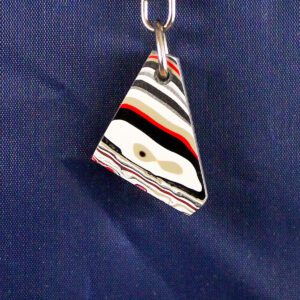 Triangular pendant with colorful layered design.