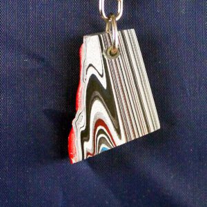 Layered paint keychain with abstract pattern.