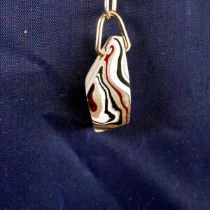 Abstract patterned pendant on blue background.