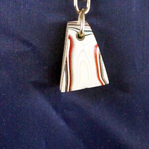 Striped keychain on blue fabric background.