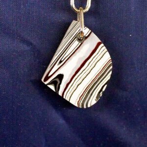 Striped keychain on blue fabric background.