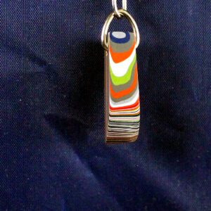 Colorful car paint layers keychain on display.