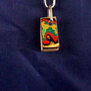 Colorful pendant with abstract design on chain.