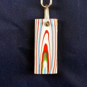 Colorful layered pendant on dark background.