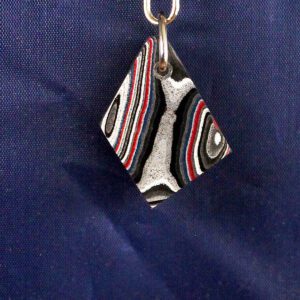 Colorful patterned pendant on blue background.