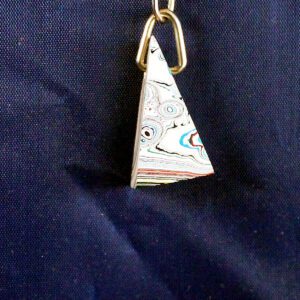 Colorful pendant on blue fabric background.