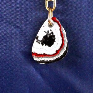 Geode keychain with red, black, white bands.