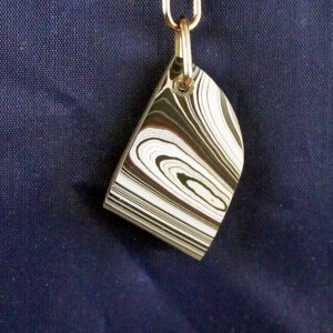 Metal keychain with swirling pattern design.