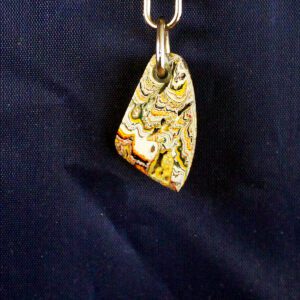 Colorful pendant with abstract pattern on chain.