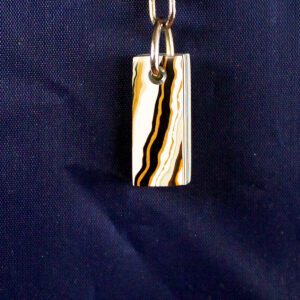 Striped rectangular pendant on blue background.