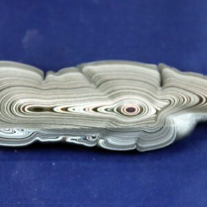 Stacked, rolled newspapers on a blue surface.
