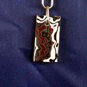 Rectangular patterned pendant on blue background.