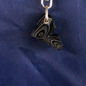 Abstract black pendant on blue background.