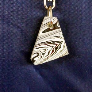 Triangular pendant with black and white swirls.