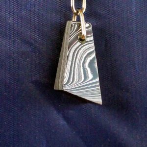 Pendant with wavy pattern on blue background.