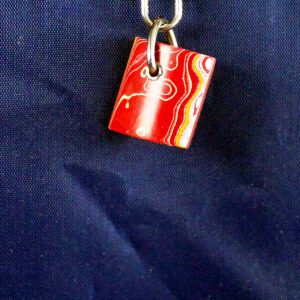 Red and white pendant on blue background.