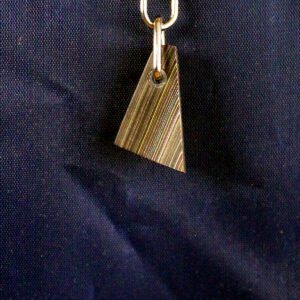 Metal pendant on a blue fabric background.