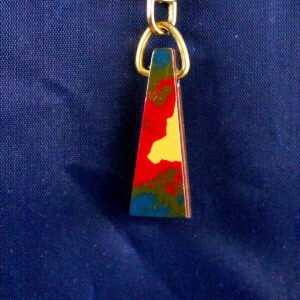 Colorful trapezoid keychain on blue background.