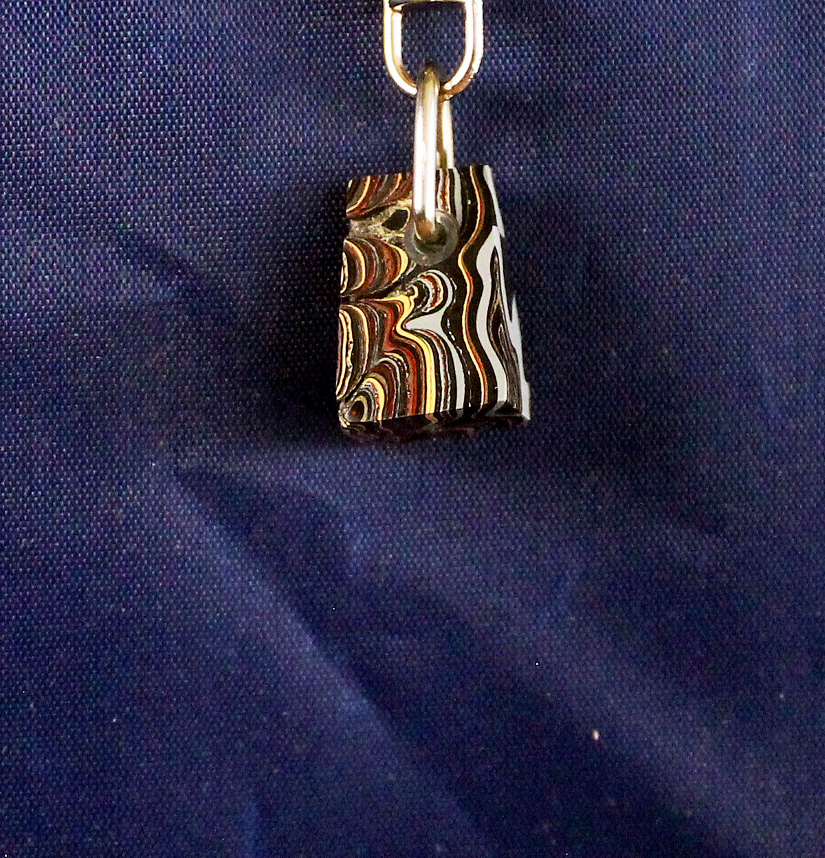 Rectangular pendant with colorful, swirling pattern.