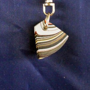 Colorful striped pendant on dark background.